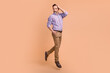 © deagreez - Photo of cheerful handsome cool man dressed striped shirt brown pants hand on head look empty space isolated on beige color background