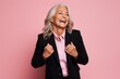 © igolaizola - Photo of happy mature business woman isolated over pink background. Looking aside.