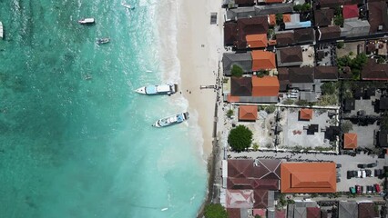 Wall Mural - Aerial shoreline view of jetty at Jungut Batu Village in Nusa Lembongan with tourist speedboat anchored on the beach. Travel destinations close to Bali island, Indonesia. 4K drone footage video