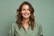© igolaizola - Portrait of a smiling woman looking at camera isolated over green background