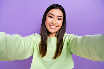 Wall Mural - Portrait of cheerful pleasant cute friendly girl wear stylish pullover making selfie on frontal camera isolated on violet color background