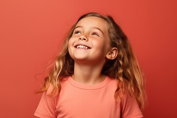 Sticker - Portrait of a smiling little girl looking up on a red background