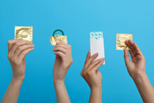 Condoms In Hand On A Blue Background