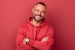 © igolaizola - Portrait of a smiling man in a red hoodie on a red background