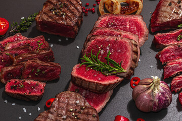 Wall Mural - Grilled set of various steaks with vegetables. Ribeye, eye round, flank and striploin steaks