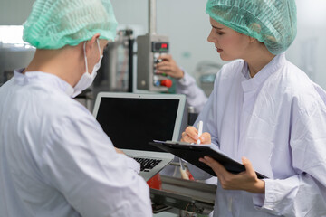 quality supervisor or food or beverages technician discuss about process control of food and drugs before send product to the customer. Production leader recheck ingredient and productivity.