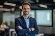 © igolaizola - portrait of smiling businessman standing with crossed arms in office at work