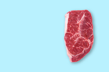 Fresh raw marble beef or pork steak ribeye on a blue isolated background. The concept of homemade healthy food.