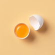 Broken egg into two halves with yolk and shell on a yellow background. Conceptual product mockup for design.