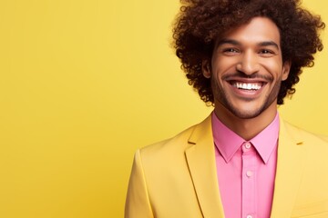 Smiling happy carefree Latino African American Hispanic stylish man with curly hair guy male model in trendy yellow suit pink shirt businessman isolated studio wall background style fashion business
