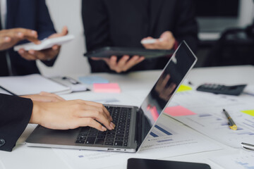 Wall Mural - Business documents on office table with smart phone and calculator digital tablet and graph business with social network diagram and two colleagues discussing data working in office