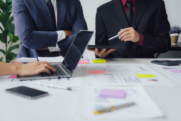 Wall Mural - Business documents on office table with smart phone and calculator digital tablet and graph business with social network diagram and two colleagues discussing data working in office