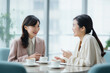 © rrice - テーブルでミーティングする2人の女性ビジネスマン