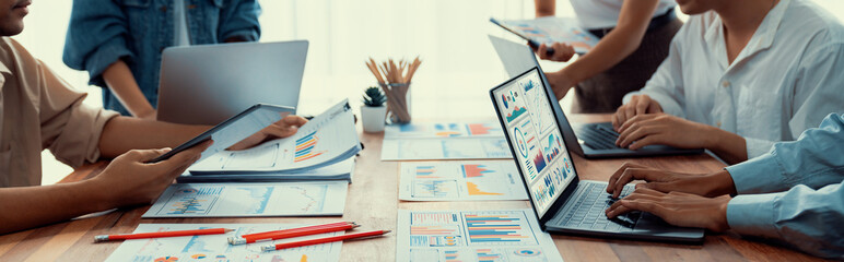 Fototapete - Panorama shot analyst team utilizing BI Fintech to analyze financial report with laptop. Businesspeople analyzing BI power dashboard displayed on laptop screen for business insight. Scrutinize