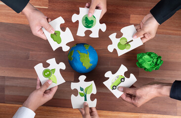 Top view cohesive group of business people holding eco icon jigsaw puzzle pieces around globe Earth as eco corporate responsibility for community and sustainable solution for greener Earth. Quaint