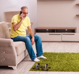 Wall Mural - Aged man doing sport exercises at home