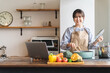© buritora - パソコンでレシピ動画を見ながら料理をする女性