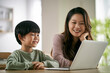 © imtmphoto - asian mother and son using laptop computer together at home