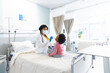 © wavebreak3 - African american female doctor wearing face mask examining girl patient at hospital