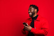 © wolfhound911 - man with phone on red background. AI Generated