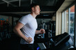 © Alexandr - A male sportsman sweating profusely while doing cardio and other physical exercises at the training gym. Fit and Focused The Power of Cardio and Gym Training for Men