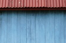 Old Blue Wooden Wall With Red Corrugated Iron Roofing Tiles, For Texture And Background.