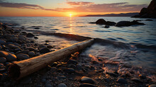 A Tranquil Coastal Scene Featuring A Beached Driftwood Log, Silhouetted Against The Setting Sun.