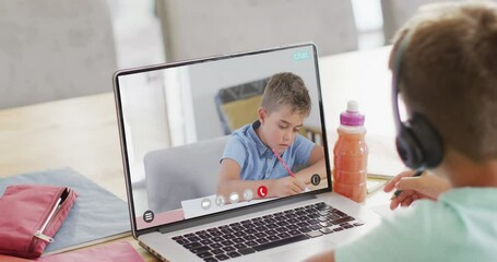 Wall Mural - Caucasian schoolboy having class on laptop video call with his friend in slow motion