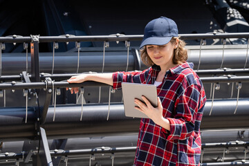 Fototapete - Woman farmer with digital tablet on a background of harvester. Smart farming concept.