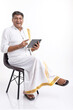 © G-images - South Indian Senior man using a digital tablet