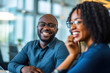 Close up of smiling African American employee look at female colleague chatting in office