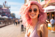 Beautiful young woman with striking pink and blonde hair. Enjoying outdoors at a lively boardwalk lined with shops and restaurants, emphasizing a carefree spirit