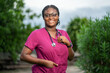 portrait of beautiful african lady in uniform, stethoscope around her neck outside- lifestyle image of black health worker outside