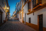 Fototapeta Uliczki - Illuminated Ronda Street at night - Ronda, Andalusia, Spain