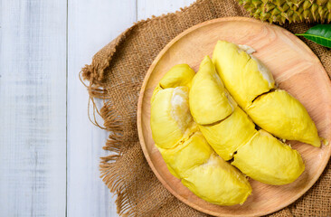 Wall Mural - Top view of Durian fruit. Ripe monthong durian on wood plate and white wood background, king of fruit