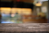 Fototapeta  - Empty dark wooden table in front of abstract blurred bokeh background of restaurant. can be used for display or montage your products.Mock up for space.