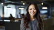 © Viktor - Portrait of happy asian woman smiling standing in modern office space.