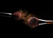 Makeup brushes with golden cosmetic powder explosion on black background