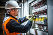 © MVProductions - Male commercial electrician at work on a fuse box, adorned in safety gear, demonstrating professionalism