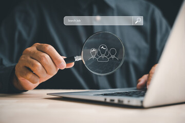 Man with magnifying glass on laptop, searching for information. Job search, internet world concept. Technology, SEO, career, education. Office desk, laptop, and magnifier. representation of searching.