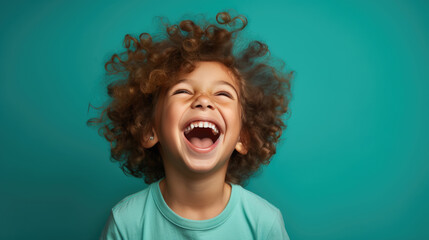 Canvas Print - Boy in a t-shirt laughing on a blue background.