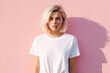 Cute young woman blonde hair with bob haircut isolated on flat pink background with copy space. Cute girl in white simple t-shirt. 