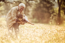 Young Boy And His Grandfather Spending Time At The Park Forest