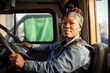 © Victor - A young black female truck driver driving. Generative AI.