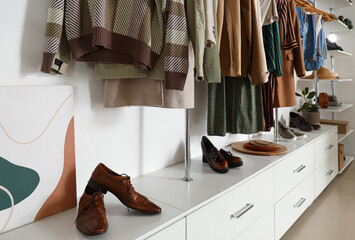 Wall Mural - Stylish clothes with modern shoes in boutique, closeup