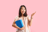 Fototapeta  - Asian Literature teacher with books on pink background