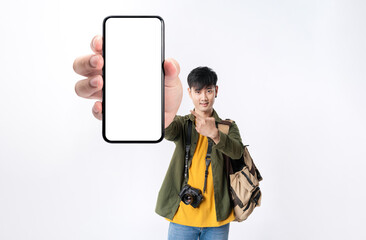 Asian man backpacker showing cellphone blank screen with hand pointing to empty space for mobile app on screen. Isolated in studio white background. Creative collage.