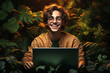 © mathiasalvez - Caucasian man between 20 and 30 years old, very happy, using his laptop while sitting among lush green plants