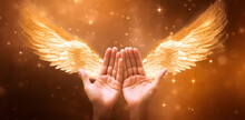 Sending Out Angelic Healing Energy - Cupped Hands With Motion Blurred Angel Wings Either Side On A Golden Boken Background With Copy Space Above.