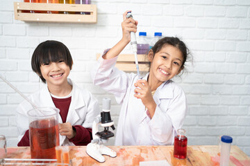 two cute little girl student child learning research and doing a chemical experiment while making an